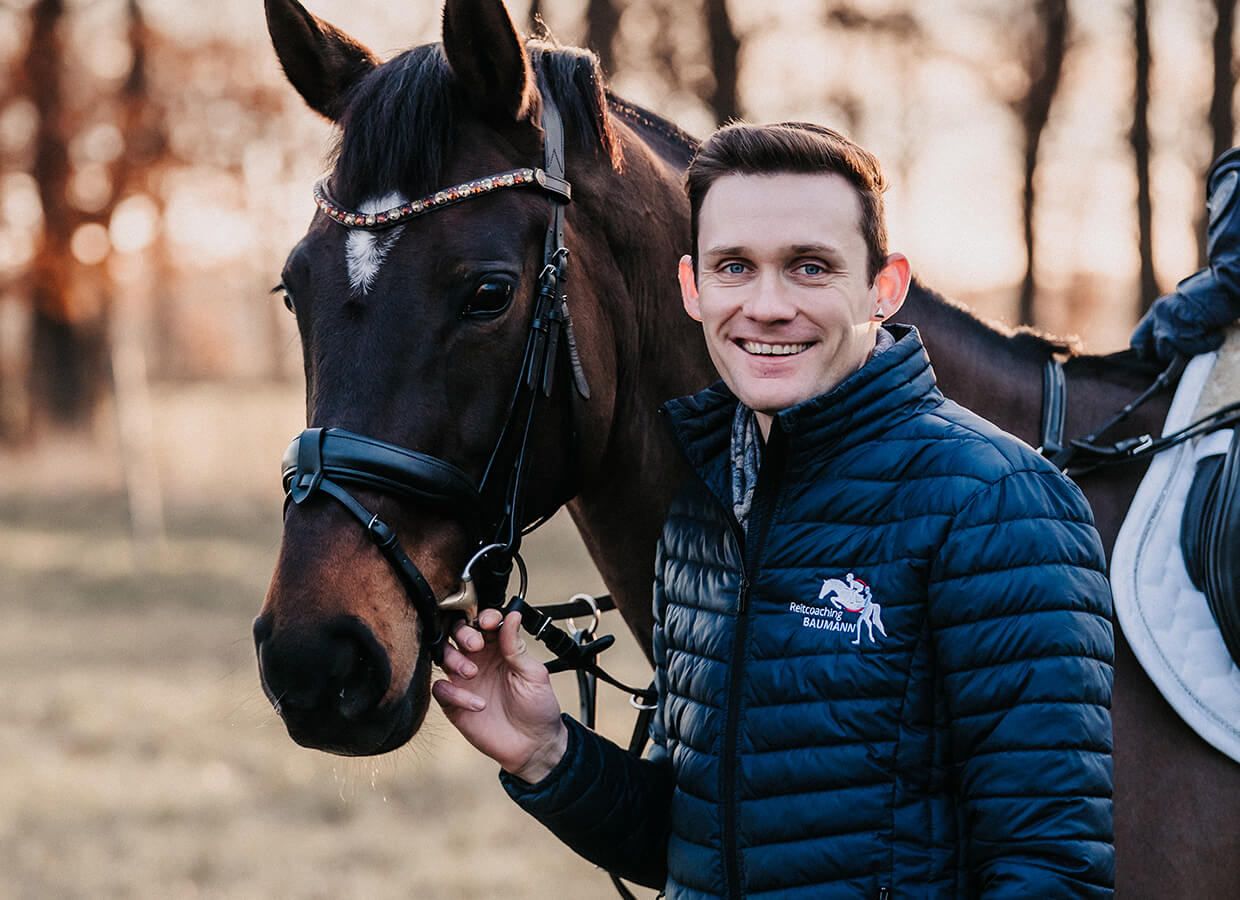 Reittrainer führt sein Pferd am Halfter