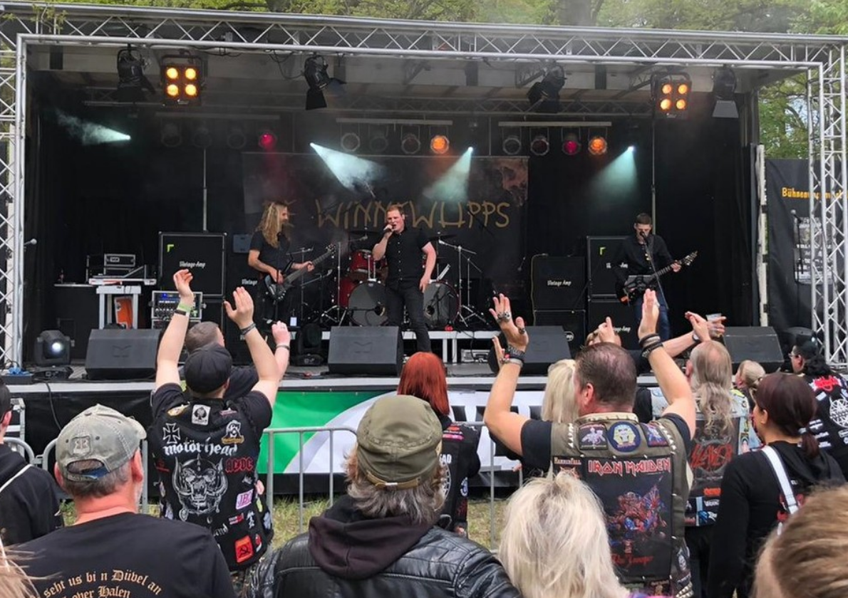 Eine Gruppe von Menschen auf einer Bühne mit einer Band auf der Bühne.