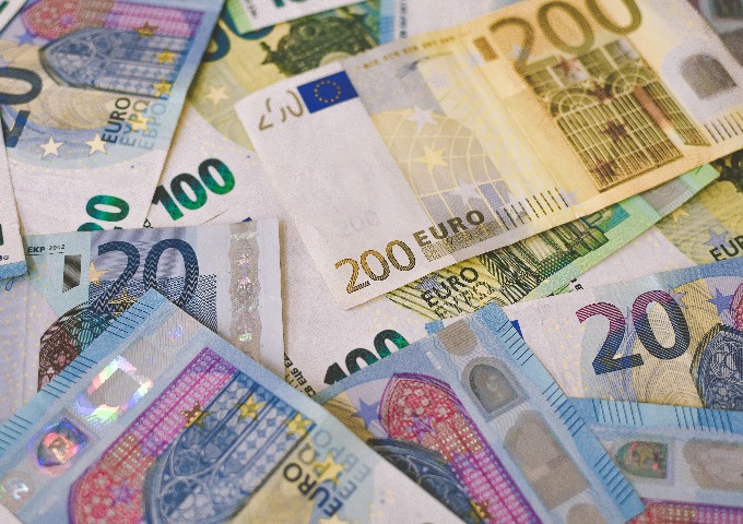 Mehrere 20-Euro- und 200-Euro-Banknoten sind auf einer flachen Oberfläche verstreut und zeigen ihre farbenfrohen Motive und Sicherheitsmerkmale.