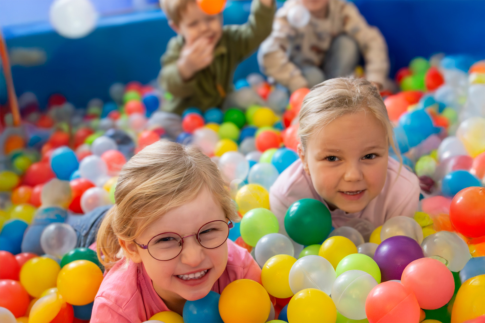 Zwei lächelnde kleine Kinder lagen in einem bunten Bällebad, umgeben von Plastikbällen, während im Hintergrund zwei weitere Kinder spielten. Die verspielte und lebhafte Atmosphäre spiegelt die fröhliche Stimmung wider, die oft bei den Gemeinschaftsveranstaltungen des Männerchors HatMannTöne Großenkneten herrscht, bei denen Lachen, Gesang und Zusammengehörigkeit stets willkommen sind.